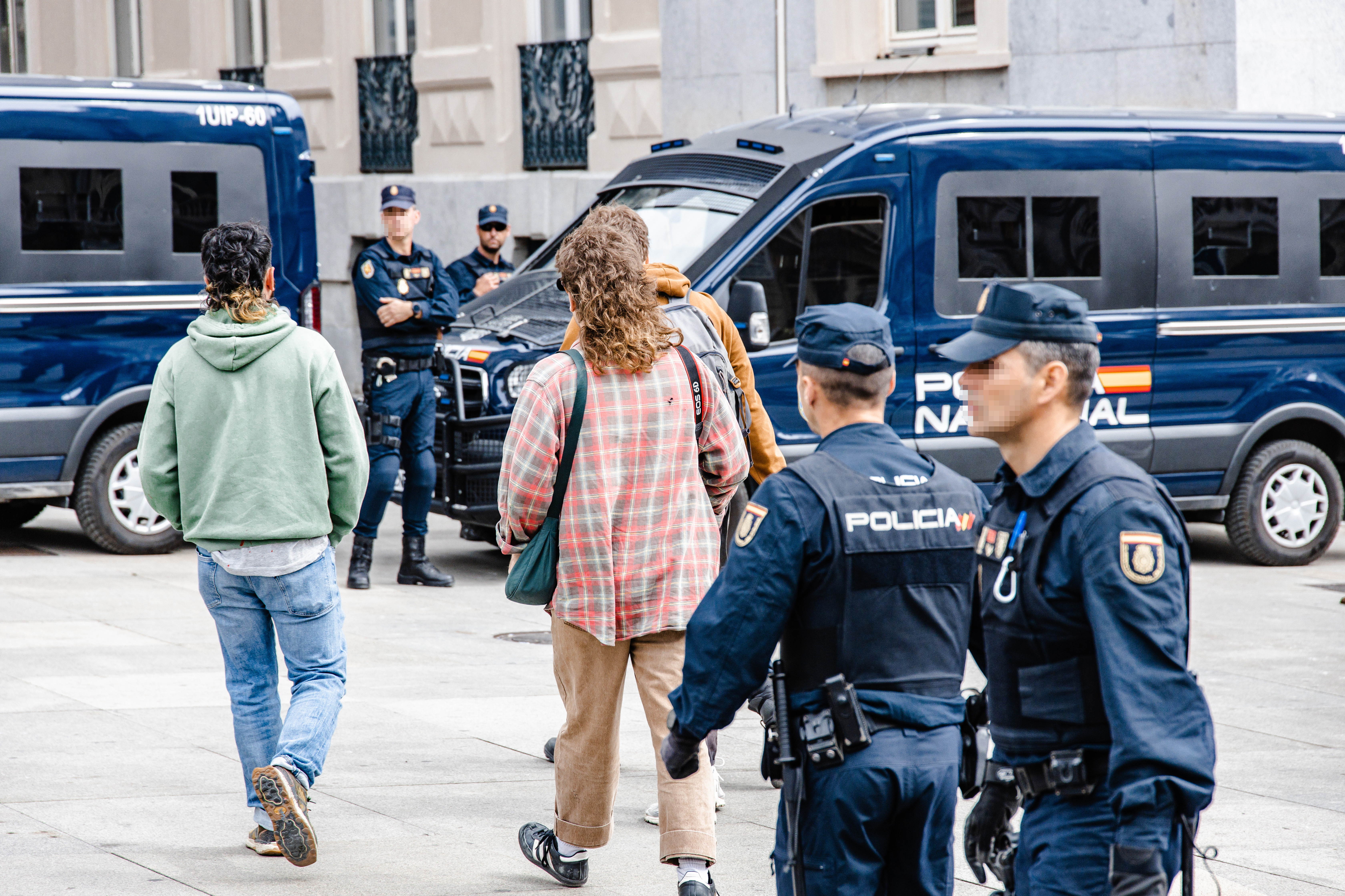 Varios activistas que han grabado la acción junto a agentes de Policía Nacional después de que activistas de Futuro Vegetal y Rebelión Científica hayan teñido de rojo las escalinatas del Congreso de los Diputados, a 30 de marzo de 2023, en Madrid (España)